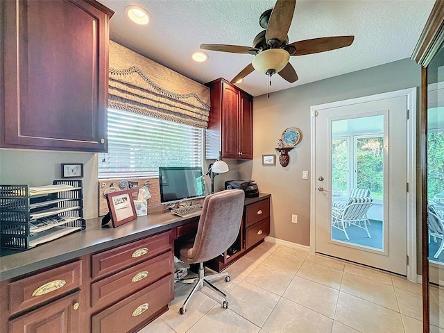 office space featuring built in desk, light tile patterned flooring, a textured ceiling, and ceiling fan