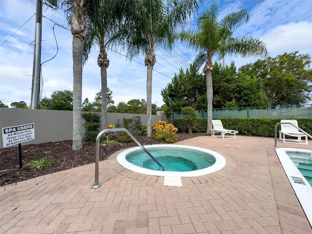 view of swimming pool featuring a hot tub