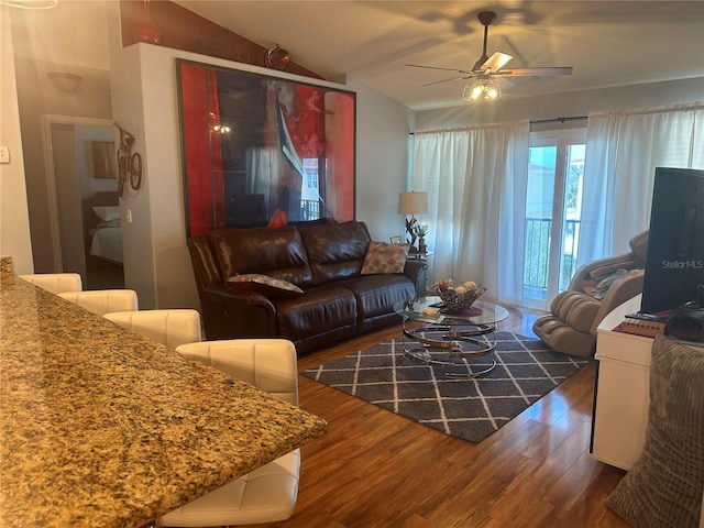 living room featuring vaulted ceiling, dark hardwood / wood-style floors, and ceiling fan