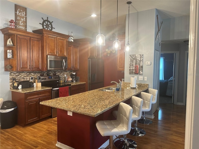 kitchen featuring decorative backsplash, stainless steel appliances, hardwood / wood-style flooring, and sink