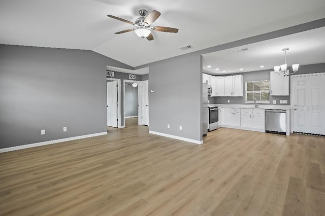 kitchen featuring white cabinetry, sink, lofted ceiling, ceiling fan with notable chandelier, and appliances with stainless steel finishes