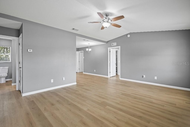 unfurnished living room featuring ceiling fan with notable chandelier, lofted ceiling, and light wood-type flooring