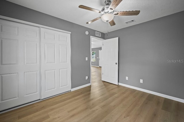 unfurnished bedroom with ceiling fan, a closet, and light hardwood / wood-style floors