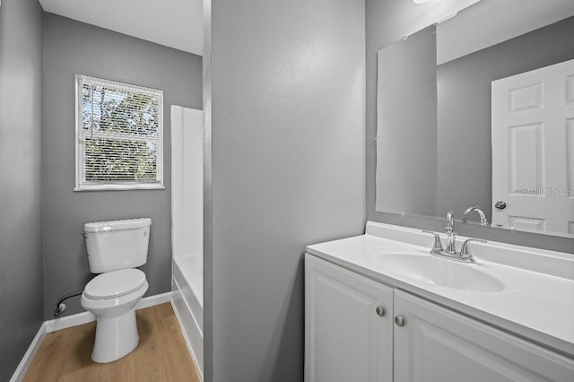 bathroom with wood-type flooring, vanity, and toilet