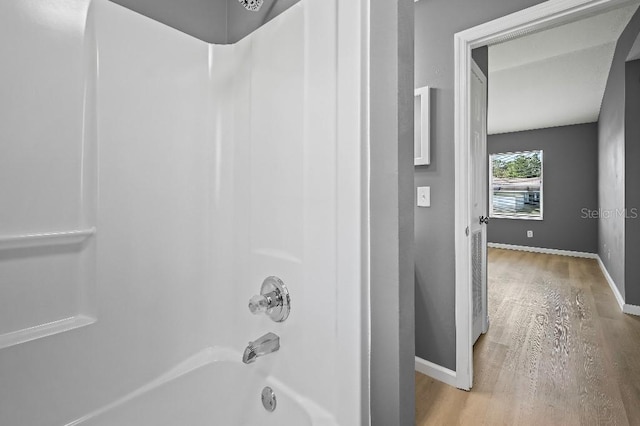 bathroom featuring hardwood / wood-style floors and bathing tub / shower combination