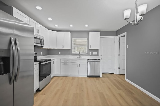 kitchen featuring pendant lighting, white cabinets, stainless steel appliances, and sink