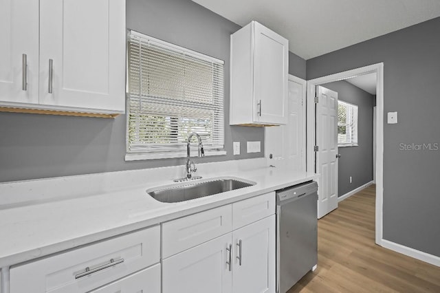 kitchen with dishwasher, white cabinets, light wood-type flooring, and sink