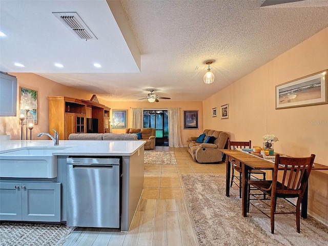 kitchen featuring sink, dishwasher, a textured ceiling, ceiling fan, and light hardwood / wood-style flooring