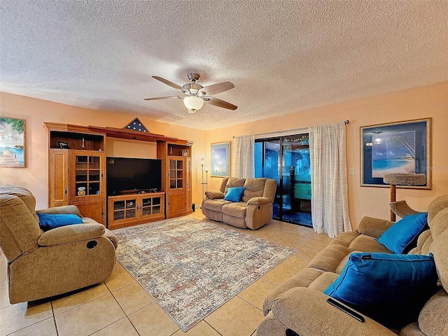 living room featuring ceiling fan, a textured ceiling, and light tile patterned floors