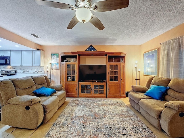 tiled living room featuring ceiling fan and a textured ceiling