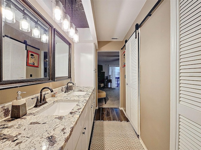 full bathroom featuring double vanity, visible vents, a closet, and a sink