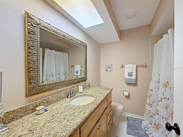 bathroom featuring toilet, a skylight, vanity, a shower with curtain, and tile patterned flooring