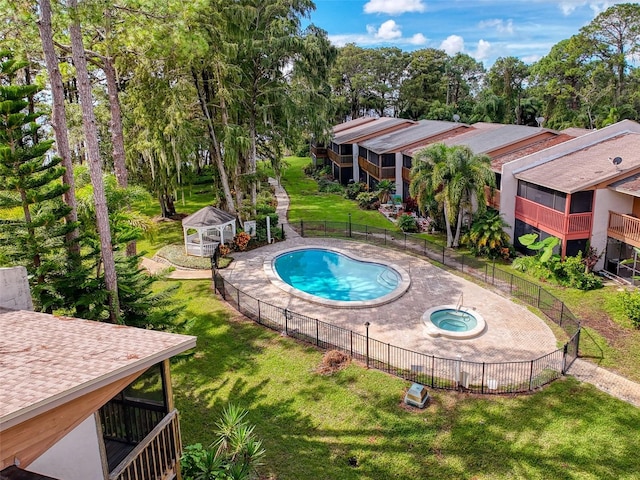 view of swimming pool with a shed, a lawn, and a community hot tub