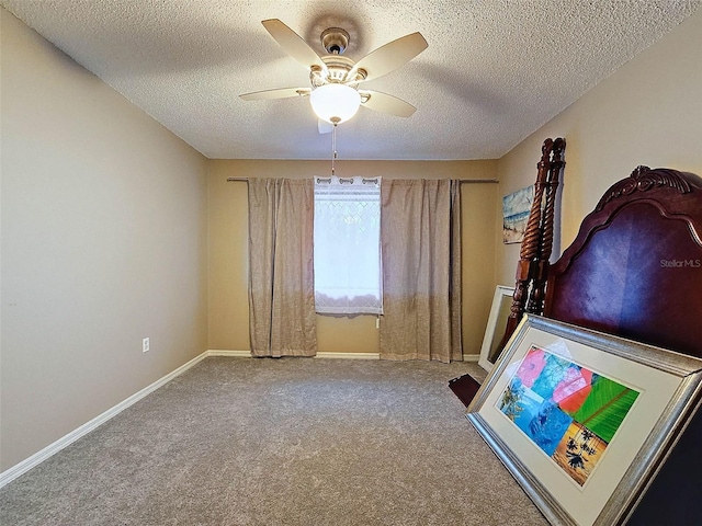 unfurnished bedroom featuring ceiling fan, baseboards, carpet floors, and a textured ceiling