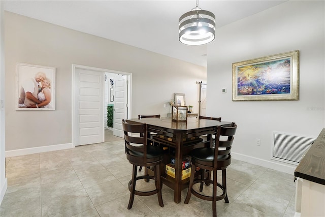 dining room with light tile patterned flooring and a notable chandelier