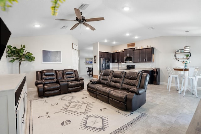 tiled living room with lofted ceiling, ceiling fan, and sink