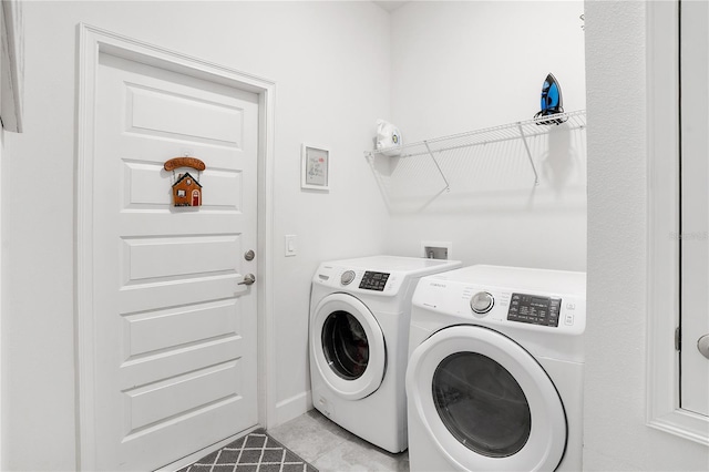 washroom with light tile patterned flooring and washing machine and dryer