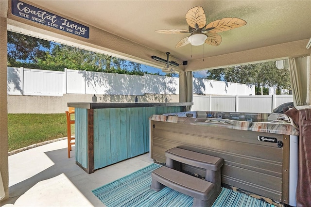 view of patio featuring ceiling fan and a hot tub