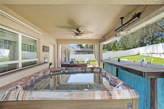 view of patio featuring ceiling fan and a hot tub