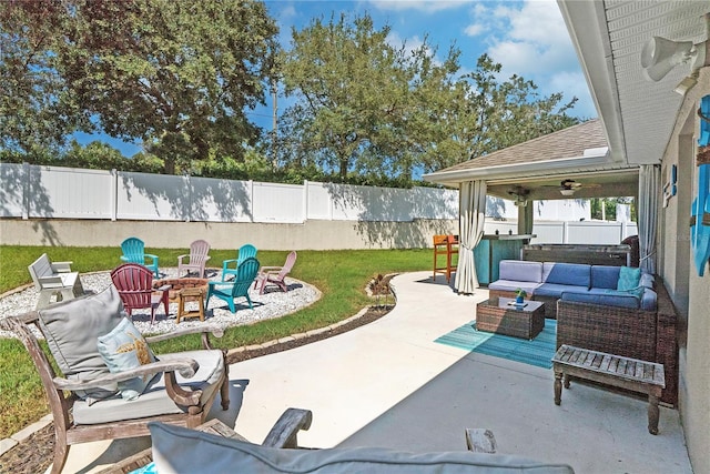 view of patio with an outdoor living space with a fire pit