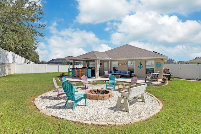 rear view of house with an outdoor living space with a fire pit, a lawn, and a patio area