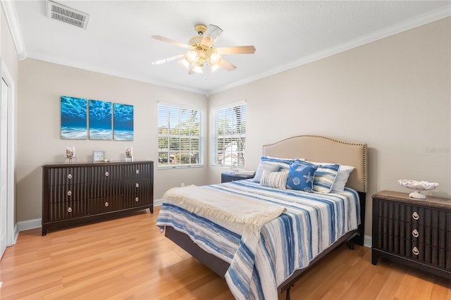 bedroom with light wood-type flooring, crown molding, and ceiling fan