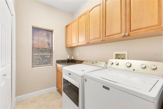 laundry area featuring light tile patterned flooring, washing machine and clothes dryer, and cabinets