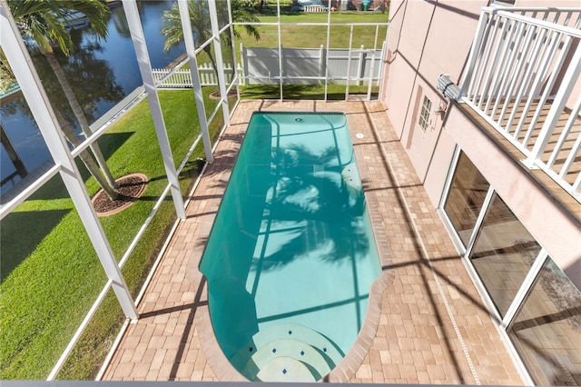 view of swimming pool with a water view, a patio, and a yard