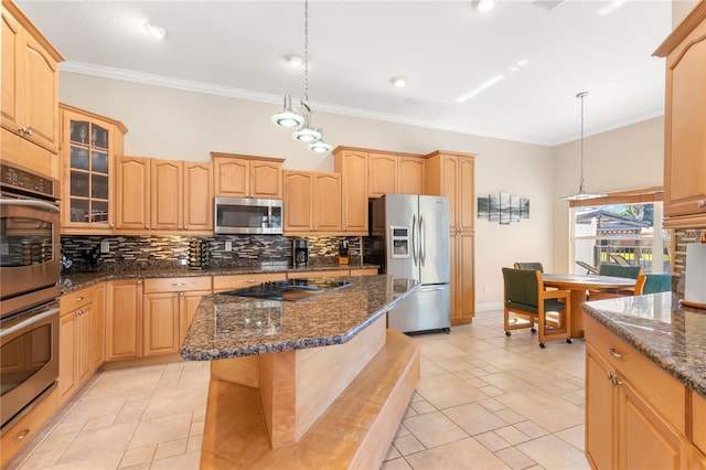 kitchen featuring stainless steel appliances, dark stone counters, decorative light fixtures, and a center island