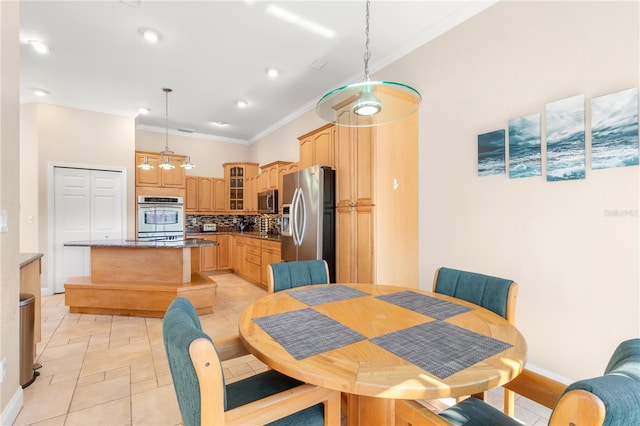 dining space featuring light tile patterned flooring and ornamental molding