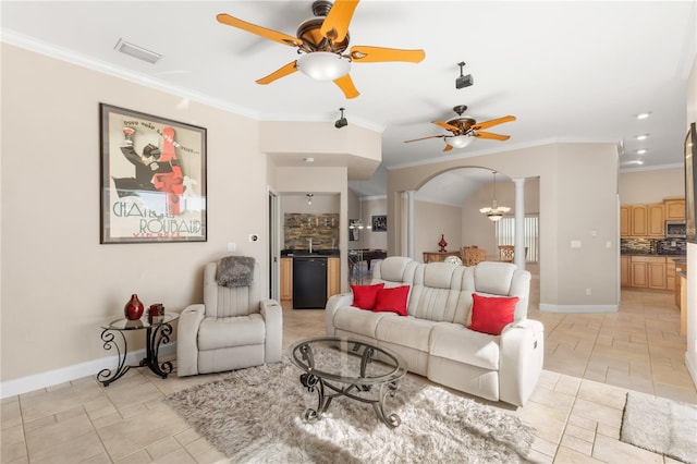 living room with ornate columns, ceiling fan with notable chandelier, and ornamental molding