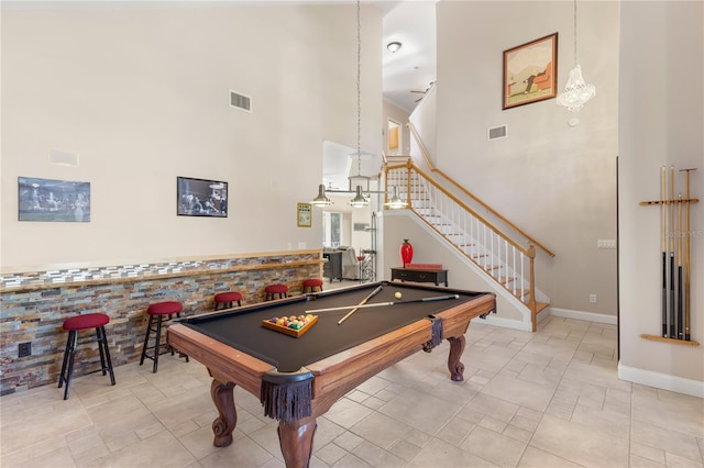 game room featuring a towering ceiling, brick wall, billiards, and ceiling fan