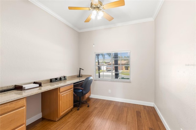 office space featuring ornamental molding, ceiling fan, built in desk, and light hardwood / wood-style flooring