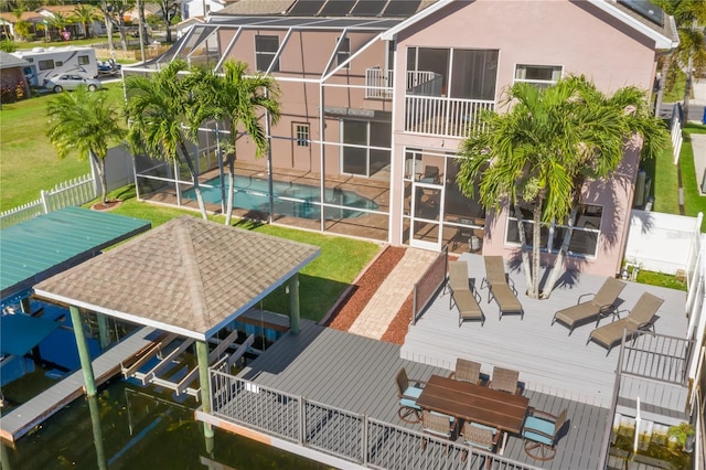 back of property featuring a yard, glass enclosure, a fenced in pool, and a patio