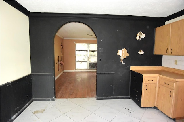 kitchen featuring light wood-type flooring, ornamental molding, and tasteful backsplash