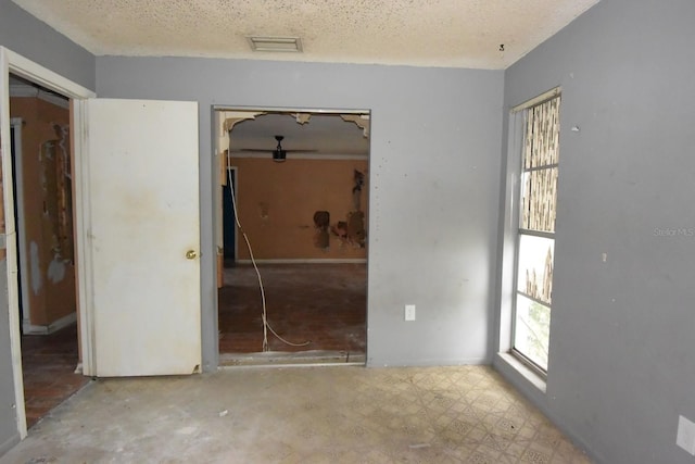 unfurnished room featuring a textured ceiling