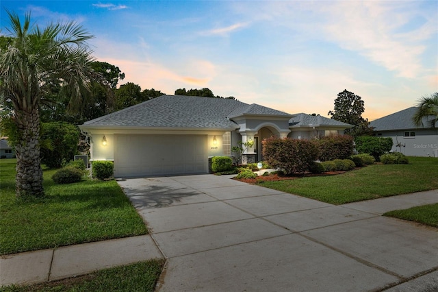 view of front of house with a yard and a garage