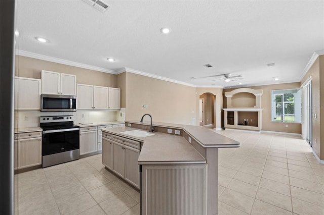 kitchen with a kitchen island with sink, stainless steel appliances, crown molding, and sink