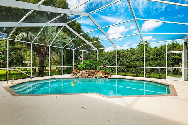 view of pool featuring glass enclosure and a patio area