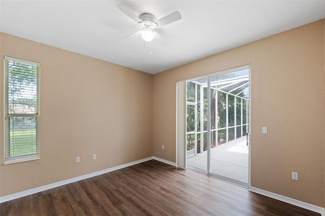 spare room with ceiling fan, dark wood-type flooring, and a wealth of natural light