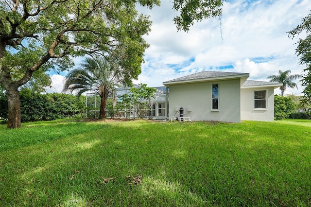 back of property featuring a lawn and a lanai