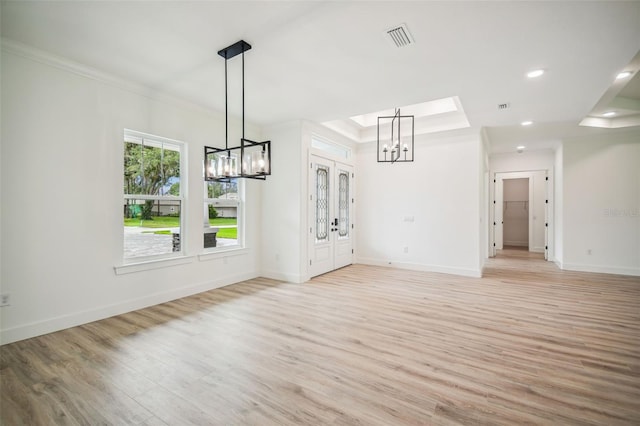 interior space with ornamental molding, french doors, and light hardwood / wood-style floors