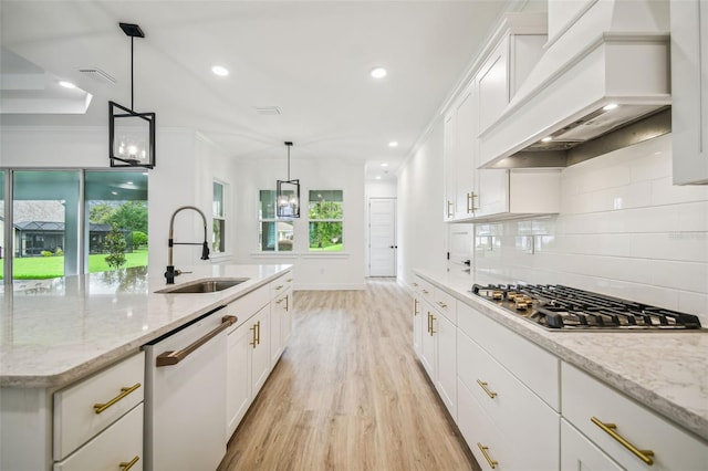 kitchen with dishwasher, sink, white cabinetry, custom exhaust hood, and stainless steel gas stovetop