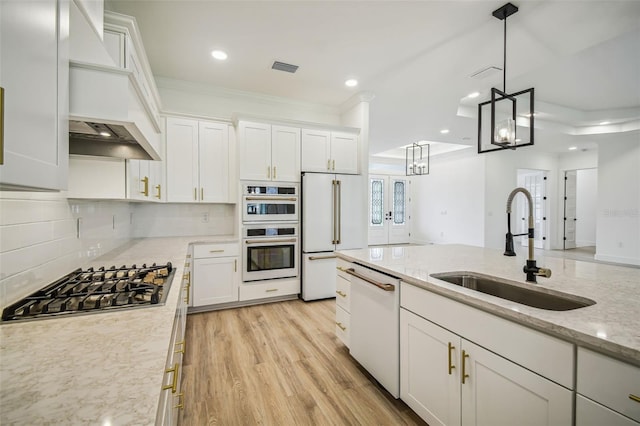 kitchen featuring sink, appliances with stainless steel finishes, light stone counters, and white cabinetry