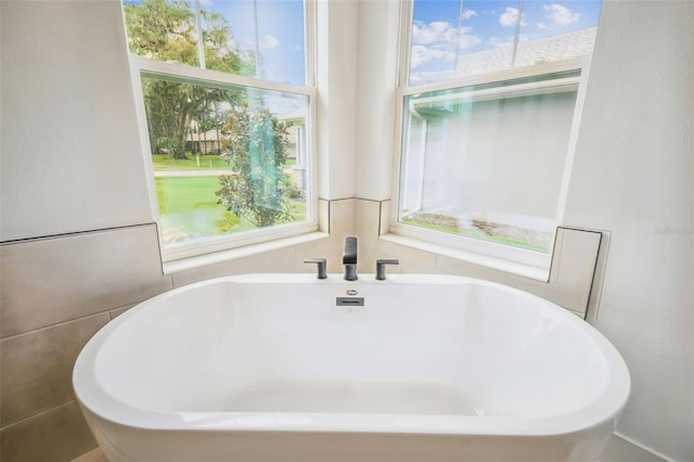 bathroom with tile walls and a bath