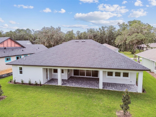 rear view of property with a yard and a patio area