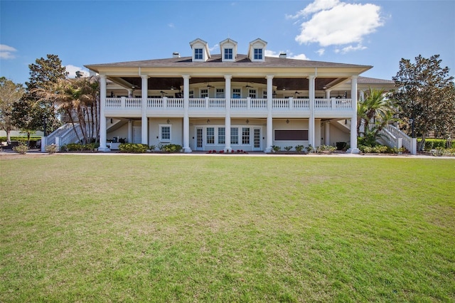 back of property featuring a ceiling fan, a lawn, and stairway