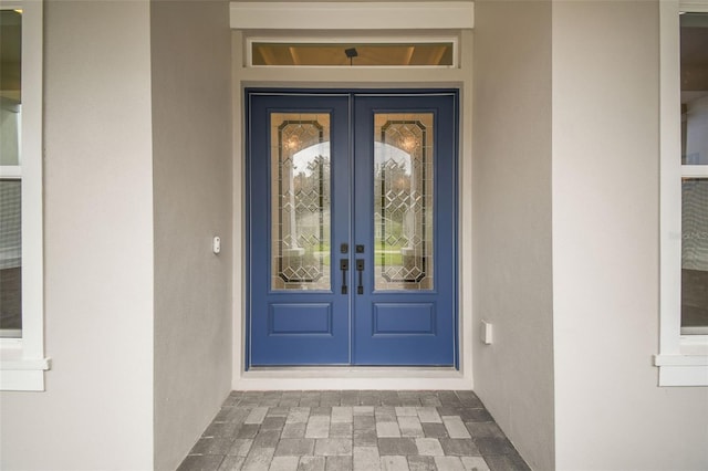 doorway to property featuring french doors and stucco siding