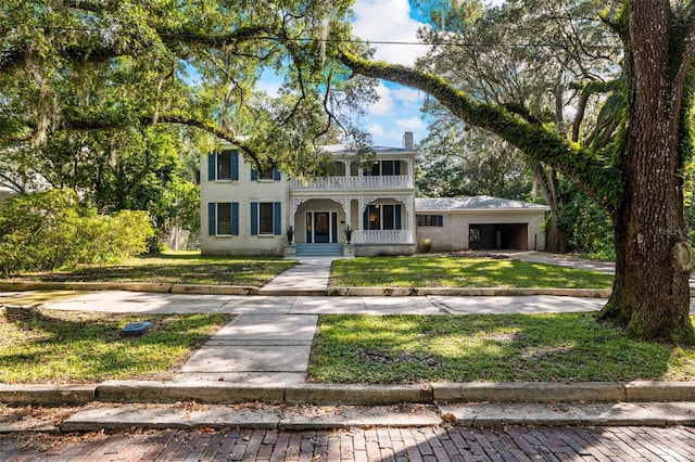 view of front of house with a balcony, a porch, and a front lawn