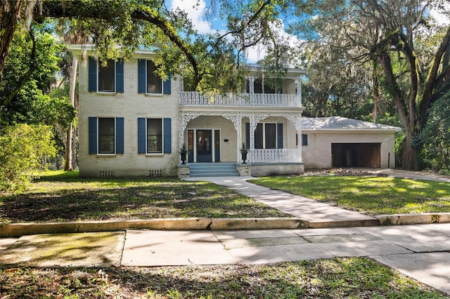 view of front facade with a balcony and a front yard